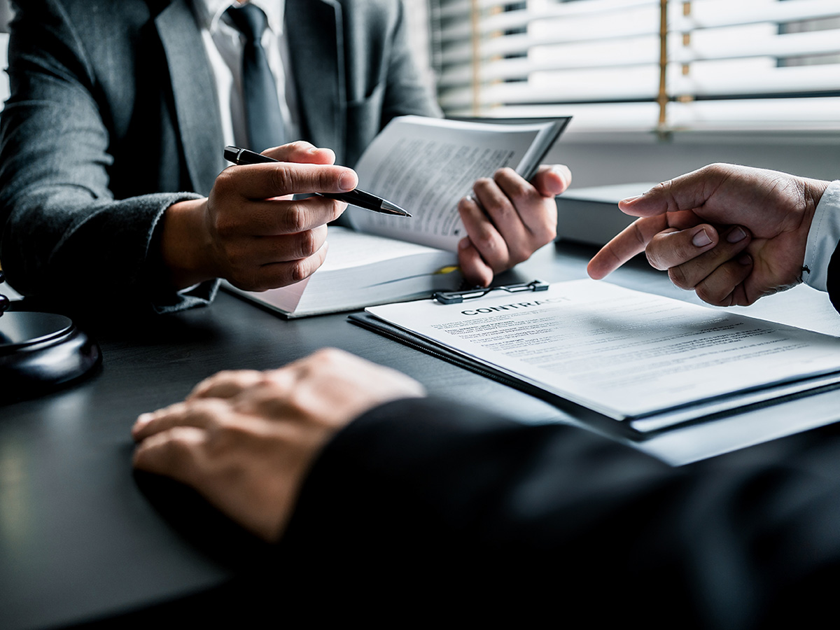 Close up of lawyers discussing contract or business agreement at law firm office